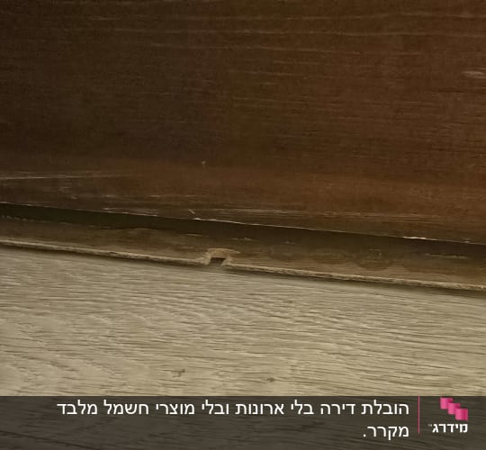 רצפת עץ עם לוח עץ שבור מתחת לרהיט